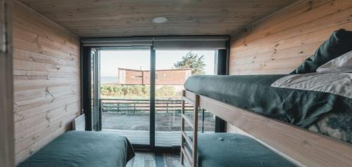 a bedroom with two bunk beds and a large window at Morros del Pacífico in Pichilemu
