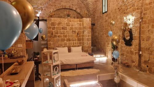 a room with a bed and balloons in it at Honey suite in ‘Akko