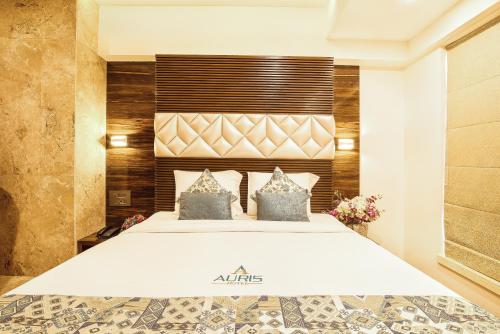 a bedroom with a large bed in a room at Hotel Auris & Banquets, Mumbai International Airport in Mumbai