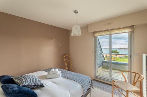 a bedroom with a bed and a large window at HEOL - appartement 2 chambres - vue mer et parking in Dinard