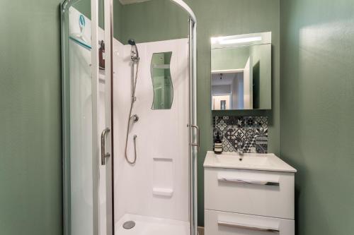 uma casa de banho com um chuveiro e um lavatório. em HEOL - appartement 2 chambres - vue mer et parking em Dinard