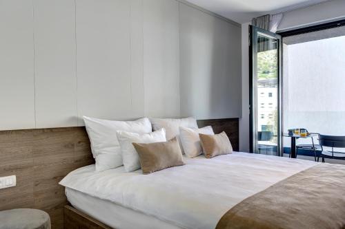 a bedroom with a large bed with white sheets and pillows at Four Blue Seasons - Luxury Apartments Dubrovnik in Dubrovnik