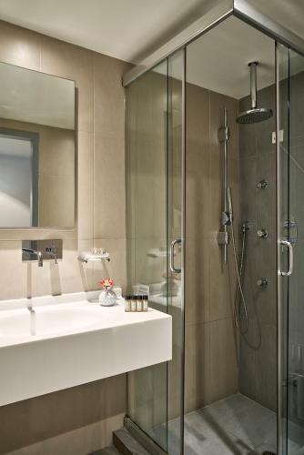un baño con lavabo y ducha en Oxygen Favie, en Tinos