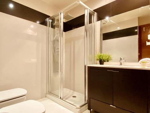 a bathroom with a shower and a toilet and a sink at Orzan Beach Surf Apartment in A Coruña