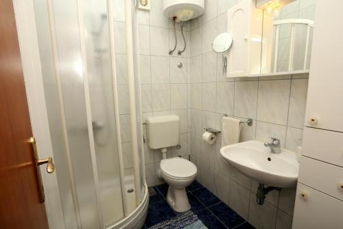 Apartments Sikirica في تروغير: حمام صغير مع مرحاض ومغسلة
