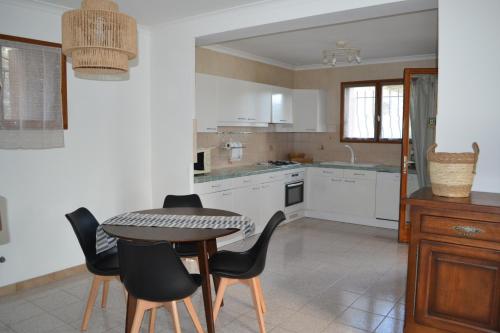 une cuisine avec une table, des chaises et une table dans l'établissement Maison au cœur des Cévennes Méridionales, à Saint-André-de-Majencoules