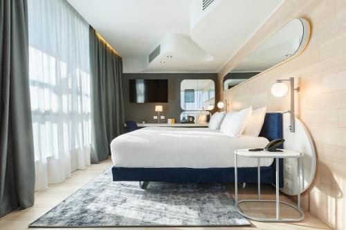 una habitación de hotel con una cama grande y una mesa en voco Milan-Fiere, an IHG Hotel, en Milán