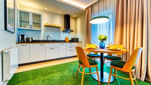 a kitchen with a table and chairs in a kitchen at Apartamenty VIP Centrum - Wczasowa 17 by Royal Aparts in Świeradów-Zdrój