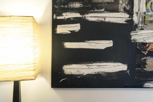 a black and white painting on a wall next to a lamp at Todi Centro - Le Terrazze di San Fortunato in Todi