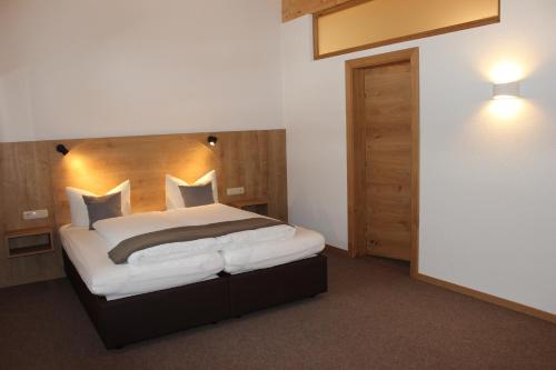 1 dormitorio con 1 cama grande y cabecero de madera en Apart Luibisblick, en Sankt Leonhard im Pitztal