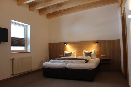 1 dormitorio con 1 cama grande y cabecero de madera en Apart Luibisblick, en Sankt Leonhard im Pitztal