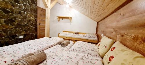 Un dormitorio con dos camas y una pared de piedra. en Chata Oddychovka, en Demänovská Dolina