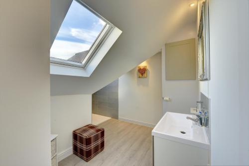 a bathroom with a sink and a skylight at Tunlaw Cottage in Kineton