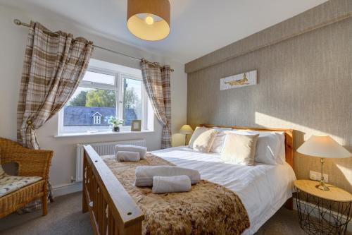 a bedroom with a large bed and a window at Tunlaw Cottage in Kineton