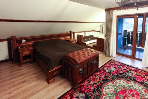 een slaapkamer met een bed, een tafel en een tapijt bij Vila Etnica in Trebujeni