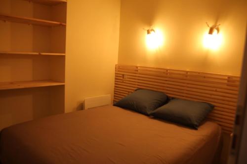 um quarto com uma cama com duas almofadas em Plein cœur Cauterets: Appartement 6/8 personnes em Cauterets