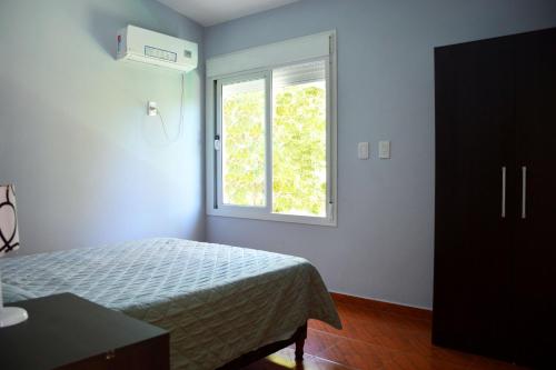 1 dormitorio con cama y ventana en Complejo Belu en Santa Rosa de Calamuchita