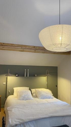 a bedroom with a large white bed with a light at Reine Sophie in Megève