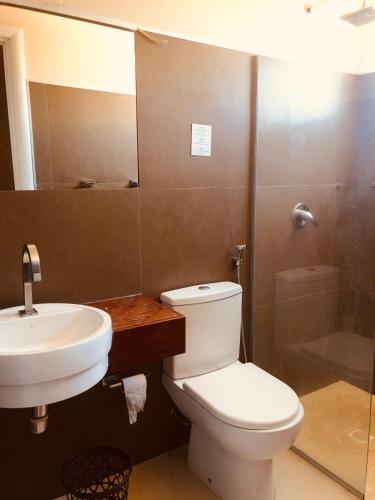 a bathroom with a toilet and a sink and a shower at Vilas na Praia Residence Canoa Quebrada CE Apartamento PÉ NA AREIA superior com 2 suítes, vista para a Praia e Dunas e com privacidade total in Canoa Quebrada