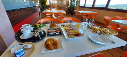 a table with breakfast food on it in a restaurant at Hotel Font del Pla in La Jonquera