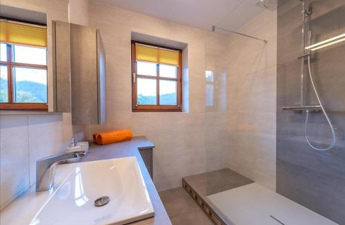 uma casa de banho branca com um lavatório e um chuveiro em Ferienwohnung Kogelblick em Ebensee