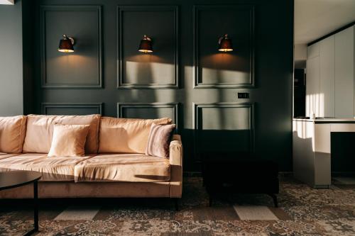 a couch in a living room with green walls at Palace Hotel & SPA in Mitrovicë