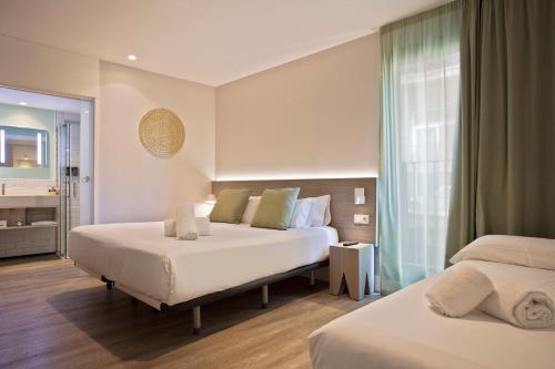 a hotel room with two beds and a bathroom at Niu Barcelona Hotel in Barcelona