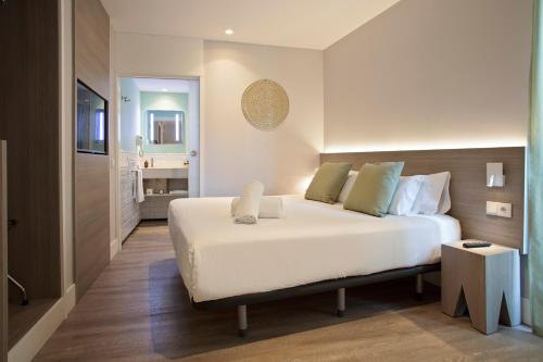 a bedroom with a large white bed and a bathroom at Niu Barcelona Hotel in Barcelona
