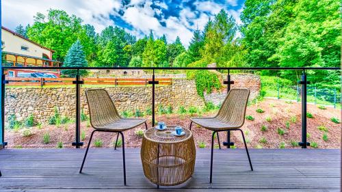two chairs and a table on a deck at Apartamenty VIP Centrum - Wczasowa 17 by Royal Aparts in Świeradów-Zdrój