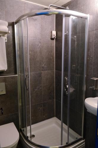 a shower with a glass door in a bathroom at Cunda Mavi Hotel in Ayvalık