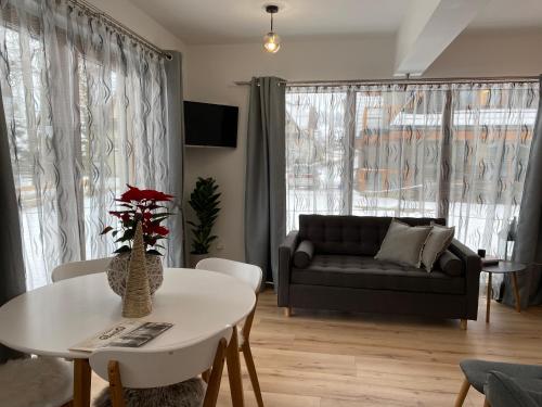 a living room with a couch and a table at Domek MAYA Górska Chata - 200m od stoków Kotelnica i Termy Bania in Białka Tatrzanska
