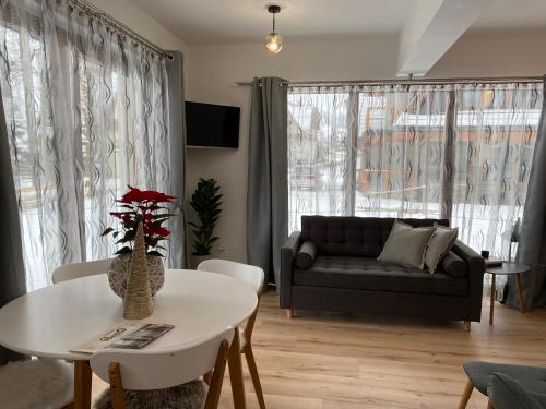 a living room with a couch and a table at Domek MAYA Górska Chata in Białka Tatrzańska