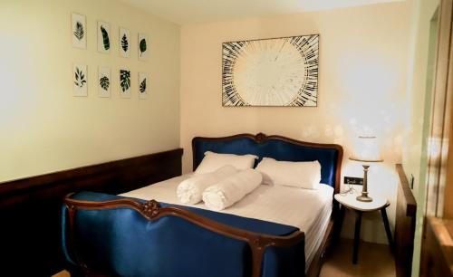 a bedroom with a blue bed with white sheets and pillows at Joglo Jawa Jepara in Jepara