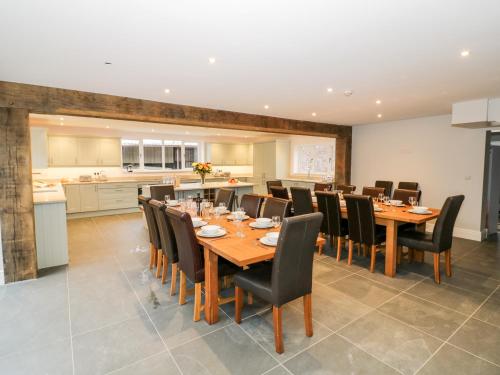 a large dining room with a long table and chairs at Lea Farm House in Kidderminster