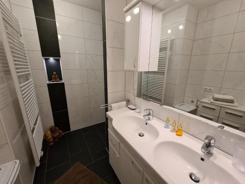 a white bathroom with a sink and a mirror at Apartment am Ziller in Schwendau