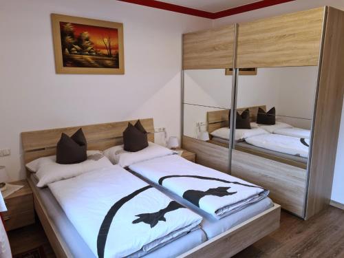 a bedroom with two beds and a mirror at Apartment am Ziller in Schwendau