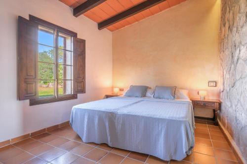 a bedroom with a white bed and a window at Es turo d Eivissa in Ses Salines
