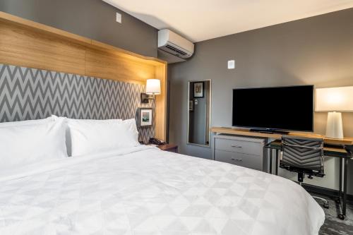a hotel room with a bed and a flat screen tv at Holiday Inn Columbia - Downtown by IHG in Columbia