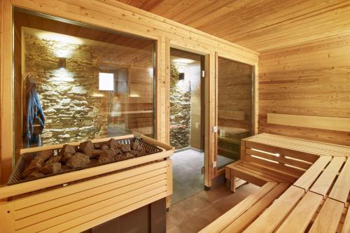 a sauna with a bench and logs in it at Schlosshotel Braunfels & Himmelreich in Braunfels
