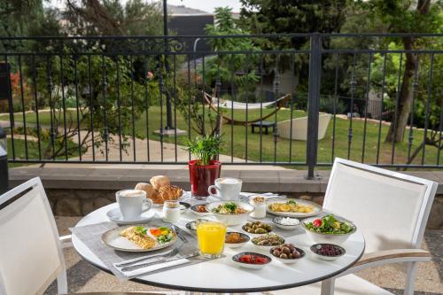 a white table with breakfast food on it at Kfar Giladi Hotel in Kefar Gil‘adi