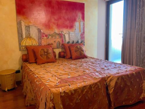 1 dormitorio con 1 cama con una pintura en la pared en B&B Guarini, en Casamassima