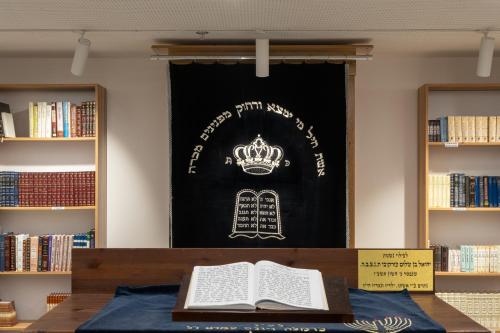 a sign in a library with a book on a table at Kfar Giladi Hotel in Kefar Gil‘adi