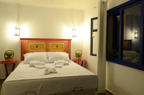 a bedroom with a white bed with two towels on it at Cunda Mavi Hotel in Ayvalık