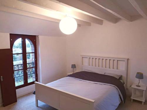 biała sypialnia z łóżkiem i oknem w obiekcie Maison de charme entre ville et campagne w mieście Amilly