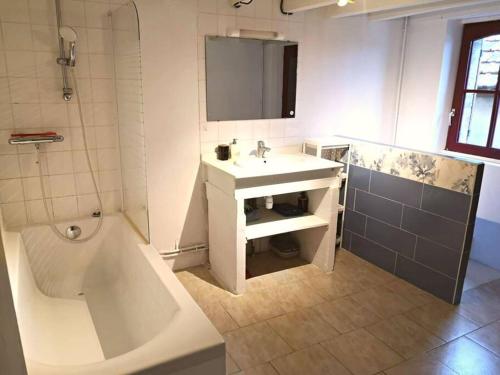 La salle de bains est pourvue d'une baignoire, d'un lavabo et d'une baignoire. dans l'établissement Maison de charme entre ville et campagne, à Amilly