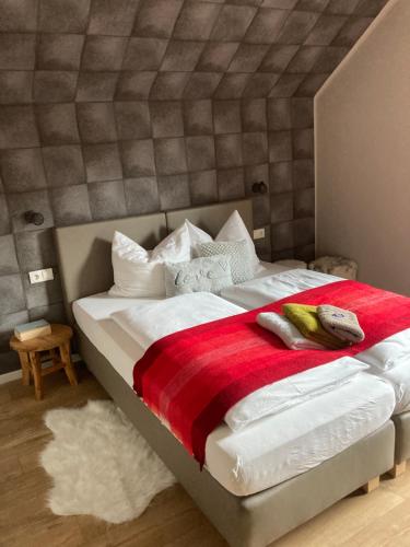 a bedroom with a large bed with a red blanket at Haus Nohra in Sankt Michael im Lungau