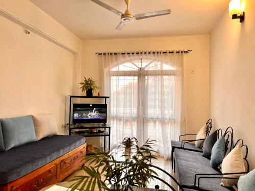 uma sala de estar com um sofá e uma televisão em Vistara By The Beach Goa em Marmagao
