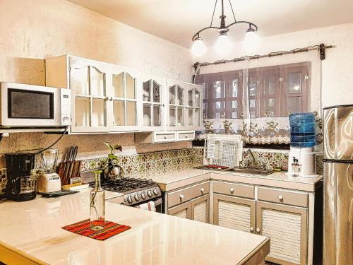 een keuken met witte kasten en een aanrechtblad bij Beachfront 3 Bedroom 2 Terraces, Hacienda del Cuyo in El Cuyo