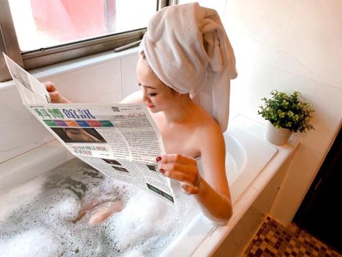 a boy in a bath tub reading a newspaper at Felicity Business Hotel in Taichung