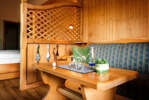 a wooden table with glasses on it in a room at Pension Krüner Stub´n in Krün